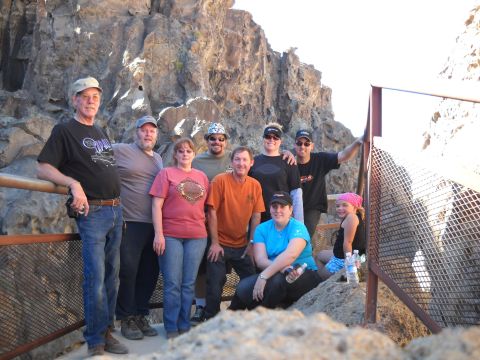 1986 Ford Bronco II - A group of people stand together on a scenic overlook, with a canyon and rock formations in the background.