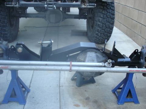 1997 Ford Ranger - Custom steering and suspension components are shown mounted on jack stands, with a vehicle's rear axle and tire visible in the background.