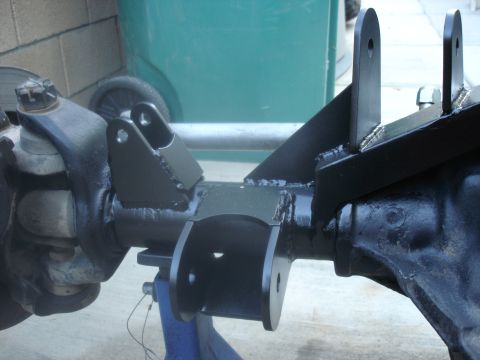 1997 Ford Ranger - Custom suspension brackets are welded onto a rear axle assembly, with a blue jack stand providing support.