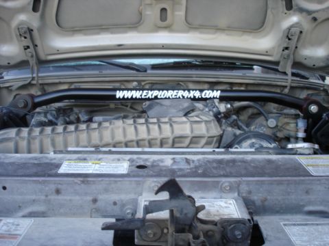 1997 Ford Ranger - The engine bay of a vehicle shows a strut bar installed above the engine components.