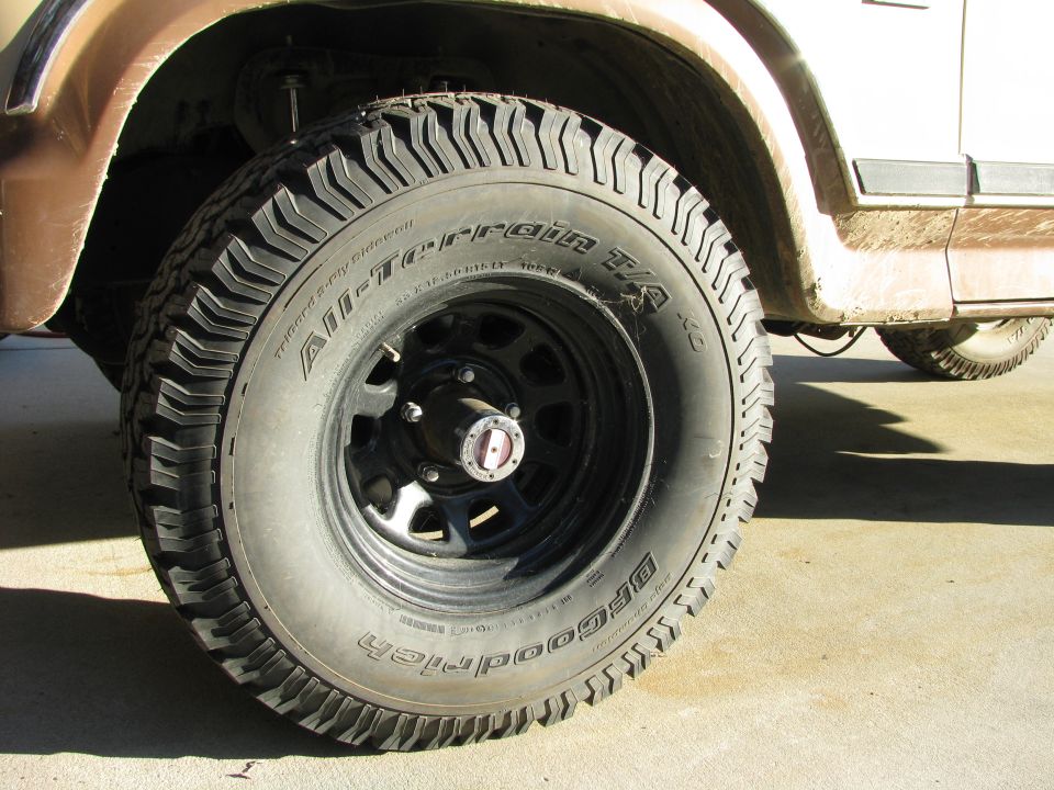 BFGoodrich All-Terrain T/A tire on black steel wheel with locking hub on tan Ford Bronco