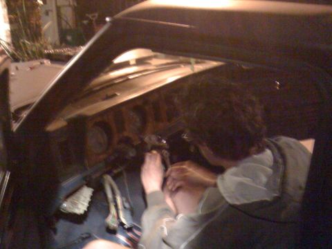 1989 Ford Bronco - Interior view of a car's dashboard and a person working on the steering column.