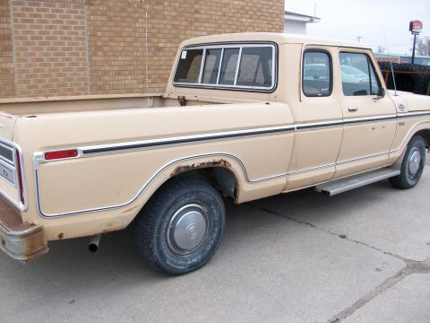 1977 Ford F-150 - This 1977 Ford F-150 crew cab pickup truck is shown from the side, displaying its tan paint and chrome trim.