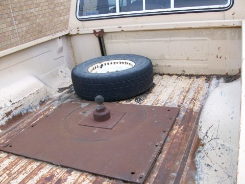 1977 Ford F-150 - Spare tire and fifth wheel hitch plate are visible in the bed of a pickup truck.