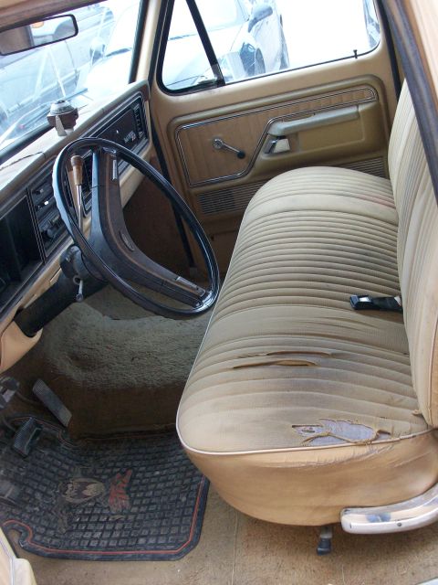 1977 Ford F-150 - The interior of a 1977 Ford F-150 features worn tan seats and a dashboard with a dashboard visible.