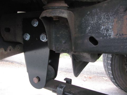 1996 Ford C-350 (Centurion Conversions) - Close-up view of aftermarket tow hook bracket installation on a vehicle's frame.
