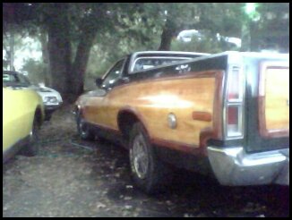 1973 Ford Ranchero - Rear view of a 1973 Ford Ranchero Squire pickup truck with distinctive wood paneling on the bed.