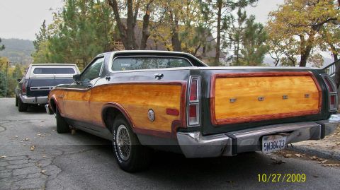 1973 Ford Ranchero - This 1973 Ford Ranchero features distinctive wood grain paneling on its tailgate and sides, parked on a street with another vehicle behind…