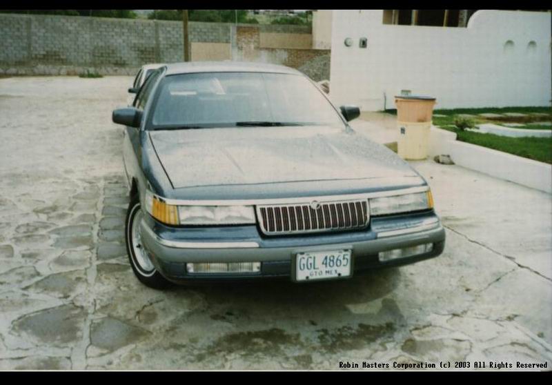 Light blue Mercury sedan, front 3/4 view, with Mexican GTO plate parked on stone driveway.