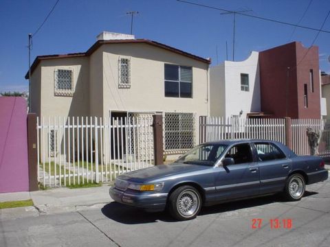 1992 Mercury Grand Marquis - A blue 1992 Mercury Grand Marquis sedan is parked in front of a house.