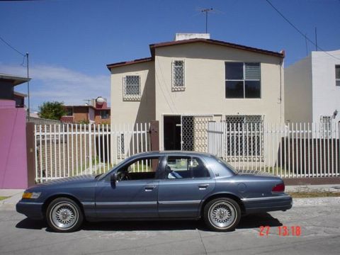 1992 Mercury Grand Marquis - A blue 1992 Mercury Grand Marquis is parked on a residential street.