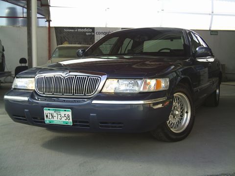 1992 Mercury Grand Marquis - A dark blue Mercury Grand Marquis is parked indoors, showing its front grille and headlights.