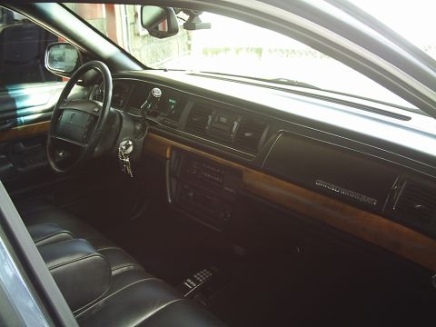 1992 Mercury Grand Marquis - The interior of a 1992 Mercury Grand Marquis features wood trim and a digital climate control panel.