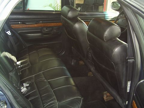 1992 Mercury Grand Marquis - Rear interior view of a 1992 Mercury Grand Marquis, black leather seats and wood trim accents.