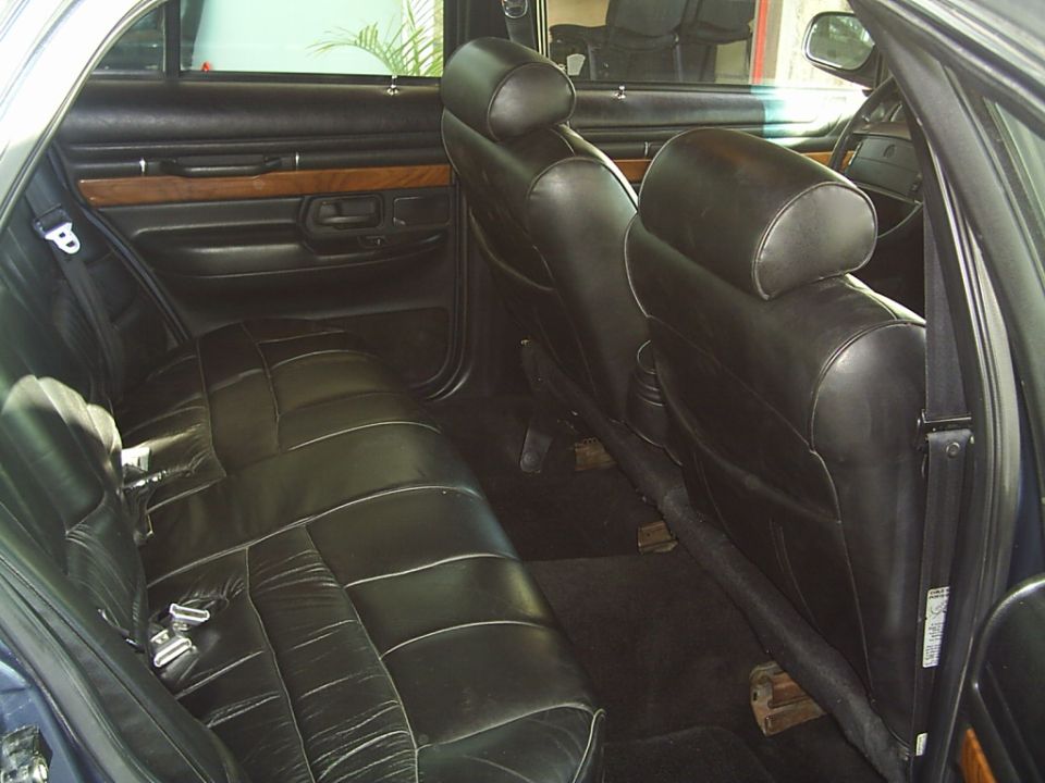 1992 Mercury Grand Marquis interior showing black leather rear seats and door panel with wood trim