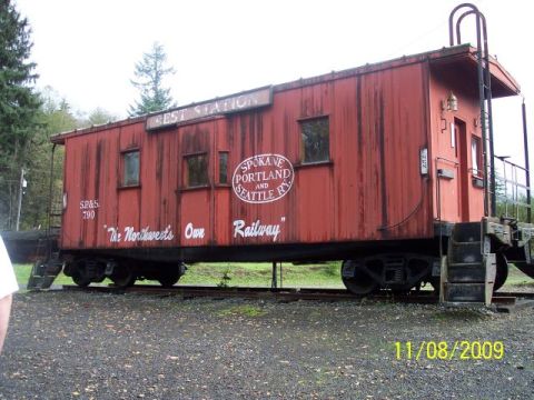 1989 Ford Bronco - A red caboose sits on train tracks, displaying various railway company logos and text.