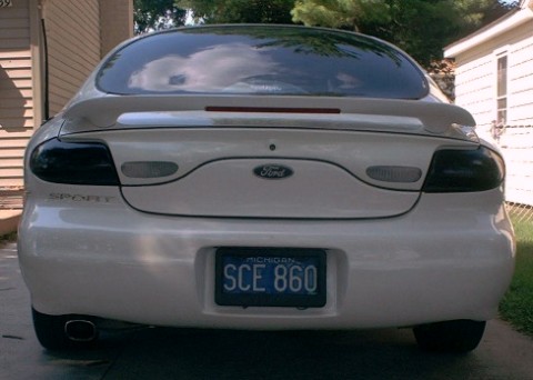 1990 Ford Taurus - Rear view of a white 1990 Ford Taurus with a spoiler and tinted taillights.