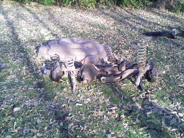 Vehicle suspension parts and a spare tire lying on the ground