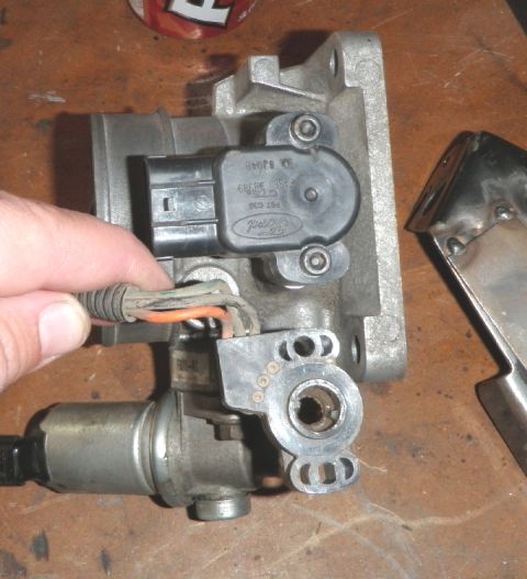 1994 Ford Bronco - A Ford throttle body assembly with its associated wiring harness and sensor is shown, likely for a vehicle part replacement or modification.