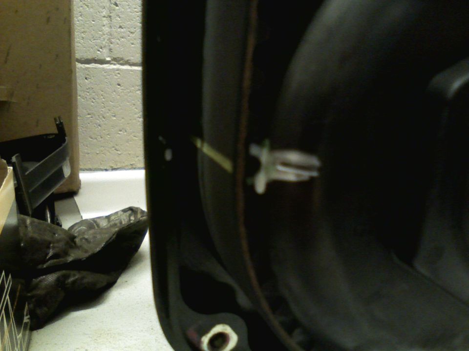 Close-up of a plastic clip on a black engine intake manifold
