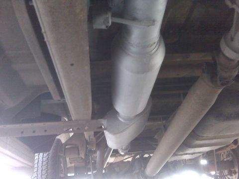 1994 Ford F-150 - The underside of a truck reveals its exhaust system, driveshaft, and other mechanical components.
