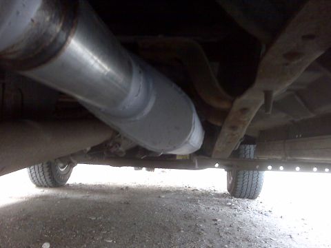 1994 Ford F-150 - The underside of a pickup truck reveals its exhaust system and frame components.