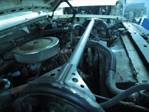 1986 Ford Bronco - Close-up view of an engine bay, showing an air filter, radiator, and a prominent silver strut bar.