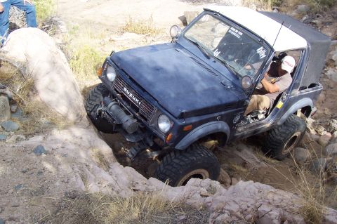 1981 Ford F-150 - This Suzuki Samurai is tackling a challenging rocky terrain, with its driver focused on the path ahead.