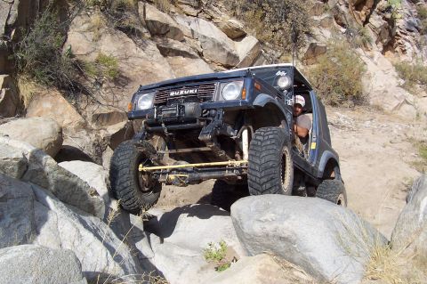 1981 Ford F-150 - A modified Suzuki Samurai navigates a rocky off-road course.