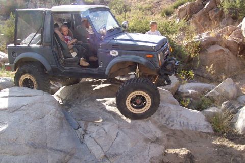 1981 Ford F-150 - An off-road vehicle traverses a challenging rocky landscape with occupants inside.