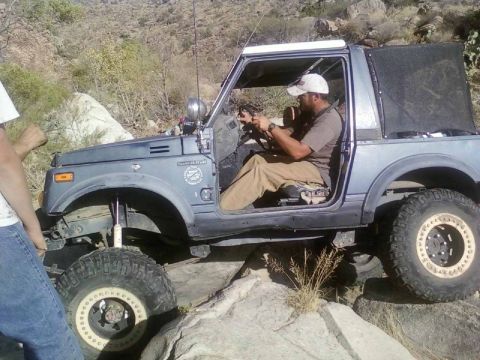 1981 Ford F-150 - A man drives a modified Suzuki Samurai over a rocky trail in a desert landscape.