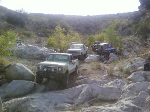 1981 Ford F-150 - Several off-road vehicles, including an International Harvester pickup, traverse a , rocky landscape.