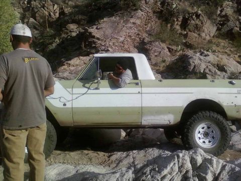1981 Ford F-150 - Pickup truck navigating a rocky trail with a person driving and another standing nearby.