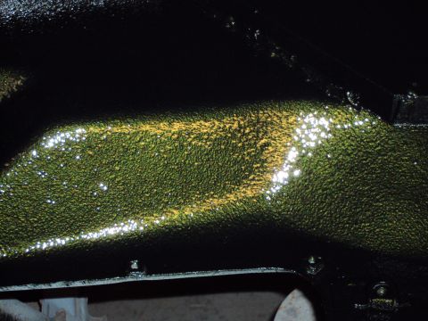 1948 Jeep Wrangler - Close-up view of the textured underside of a vehicle frame, showing green and yellow paint application.
