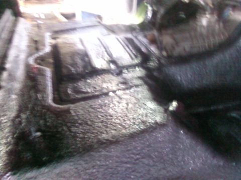 1997 Ford F-350 - The underbody of a vehicle shows significant wear and tear, with rust and dirt accumulation.