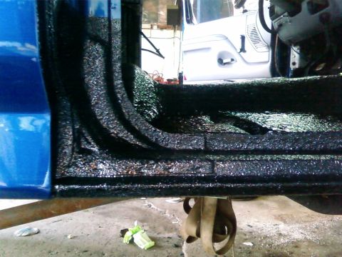 1997 Ford F-350 - The interior floor of a blue truck has been coated with black spray-on liner, with a white Jeep parked nearby.