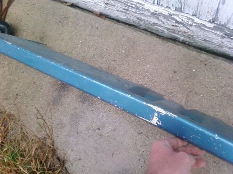 1997 Ford F-350 - A close-up view of a blue painted metal part, showing chipped paint and wear.