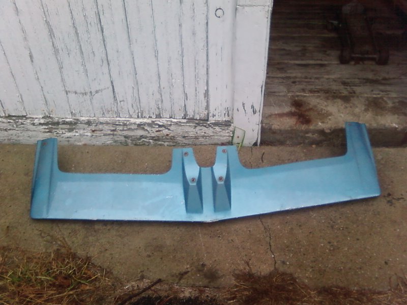 Blue sun visor with two mounting brackets, resting on concrete