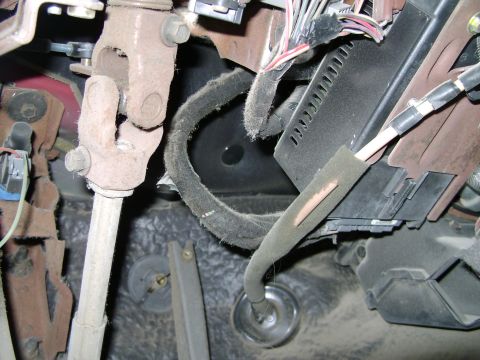 1998 Ford Crown Victoria - Close-up view of the steering column and wiring harness components beneath the dashboard.