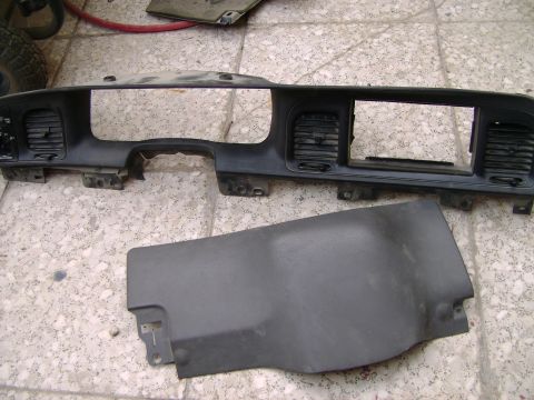 1998 Ford Crown Victoria - The dashboard instrument panel and a separate trim piece are shown disassembled on a tiled floor.