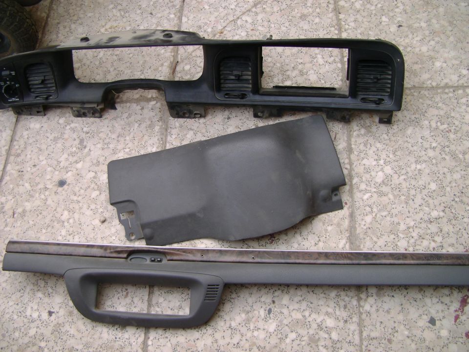 Dashboard trim pieces and vents laid out on a textured floor