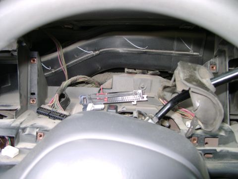 1998 Ford Crown Victoria - Close-up view of the exposed wiring harness and connectors within a vehicle's dashboard.