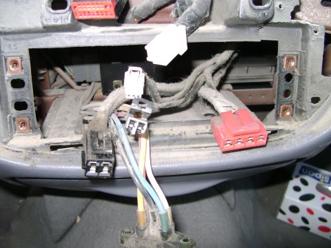 1998 Ford Crown Victoria - Close-up view of disconnected electrical connectors and wiring within a vehicle's dashboard.