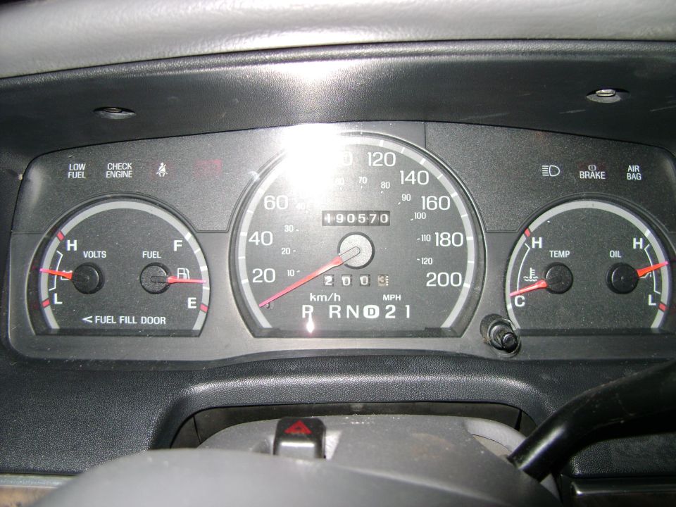 Car dashboard with speedometer, fuel gauge, volt meter, temperature gauge, and oil gauge. Odometer shows 90570