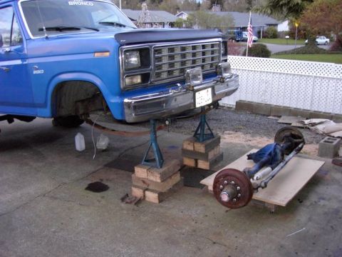 1980 Ford Bronco - Front axle removed from a blue 1980 Ford Bronco undergoing maintenance.