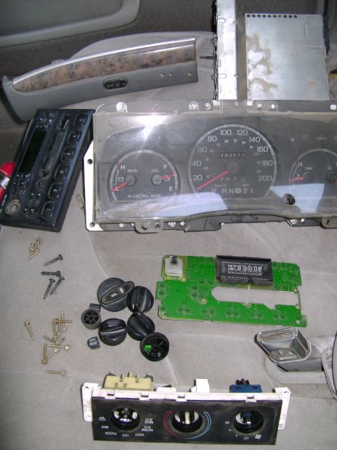 1998 Ford Crown Victoria - Disassembled interior components from a 1998 Ford Crown Victoria are laid out for cleaning.