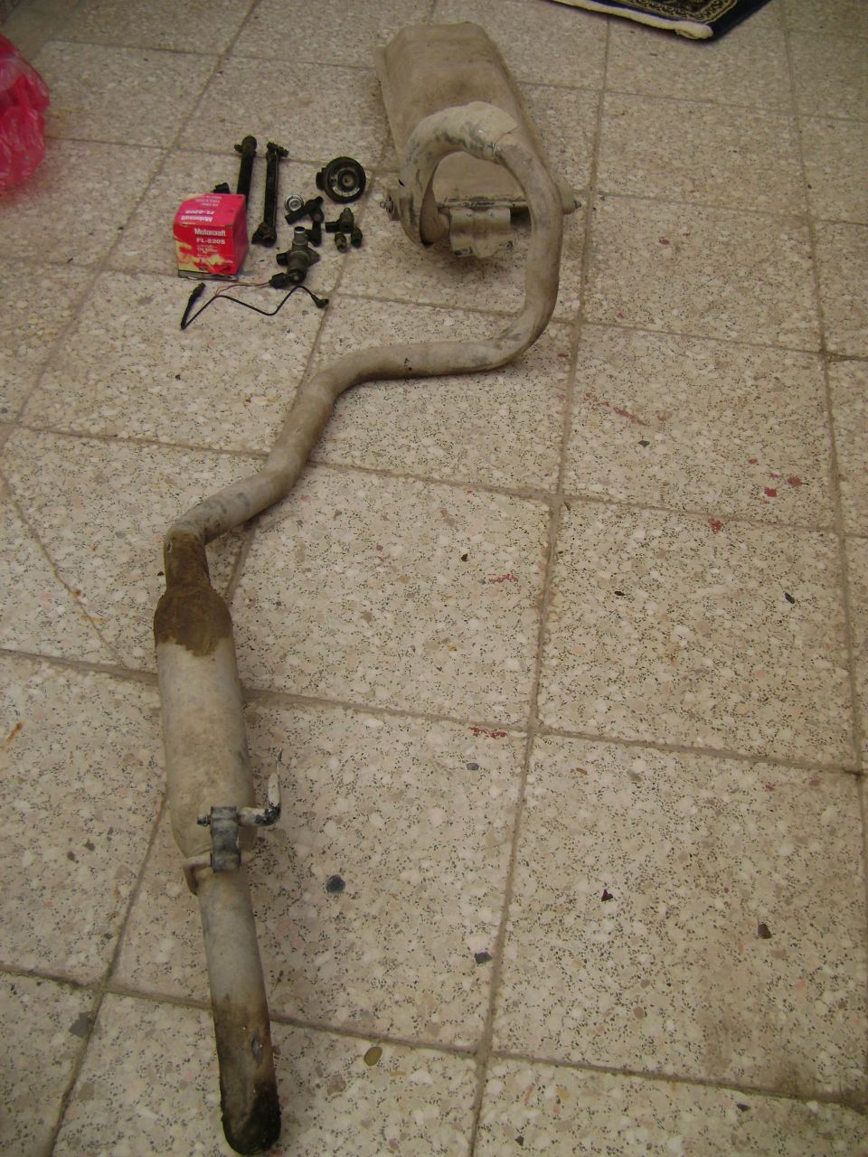 Exhaust muffler and pipe assembly with mounting hardware and a red box