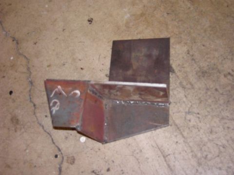 1980 Ford Bronco - A custom metal bracket, possibly for a vehicle modification, sits on a concrete surface.