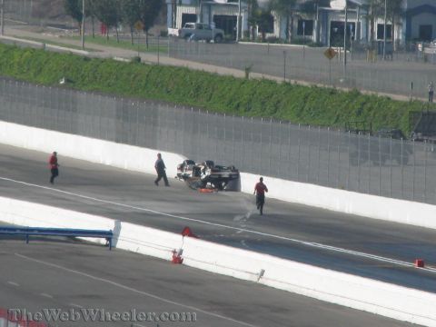 1968 Ford Mustang - Emergency personnel attend to an overturned race car on the track during the 2009 NHRA Finals Qualifying.