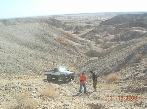 1985 Ford Bronco - Two people are near a modified white pickup truck in a desert landscape, with a date stamp of 11.13.2009.